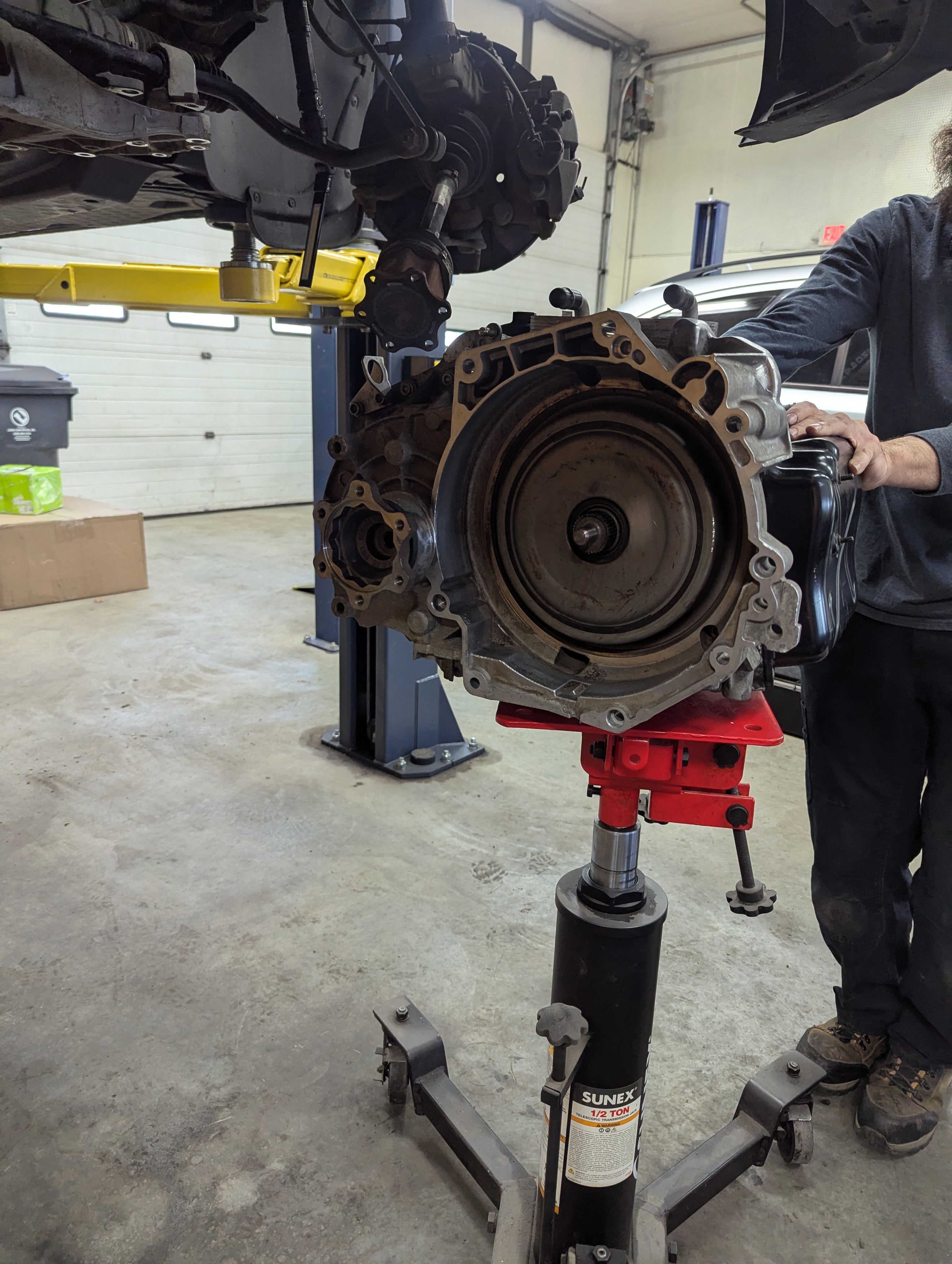 Transmission on jack stand during service at Lux AutoHause